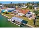 Waterfront home featuring a screened pool, boat dock with lift, and well-maintained lawn at 1575 Brookside Blvd, Largo, FL 33770