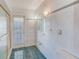 Bright bathroom with tiled walls, a walk-in shower, and ample natural light at 1575 Brookside Blvd, Largo, FL 33770