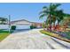 Single story home with a white garage door and palm trees at 1575 Brookside Blvd, Largo, FL 33770
