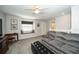Spacious bonus room with a gray couch, window seat, and a TV at 17546 Fairmeadow Dr, Tampa, FL 33647
