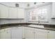 Bright kitchen with white cabinets, granite countertops, and modern appliances at 17546 Fairmeadow Dr, Tampa, FL 33647