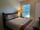 Cozy bedroom with a double bed, dresser and a window with blinds at 1799 N Highland Ave # 44, Clearwater, FL 33755