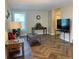 Bright living room features herringbone floors, comfy seating, and large windows at 1799 N Highland Ave # 44, Clearwater, FL 33755