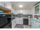 Updated kitchen with white cabinets, mosaic backsplash, and modern appliances at 2043 Denmark St # 65, Clearwater, FL 33763