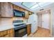 Galley kitchen with wood cabinets and appliances at 2587 Countryside Blvd # 6303, Clearwater, FL 33761