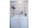 Well-lit laundry closet with shelving and full-size washer and dryer at 2587 Countryside Blvd # 6303, Clearwater, FL 33761