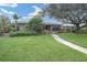 Mid-century home with a lush lawn and a tree-lined street at 266 Snell Isle Ne Blvd, St Petersburg, FL 33704