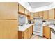 Kitchen features white appliances and wood cabinets at 3141 Lake Pine Way # D2, Tarpon Springs, FL 34688