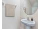 Small powder room with pedestal sink and round mirror at 33182 Osprey Peak Way, San Antonio, FL 33576