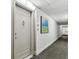 Clean apartment hallway with neutral color palette and artwork at 400 Island Way # 1204, Clearwater Beach, FL 33767