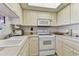 White kitchen with microwave, oven and countertops at 400 Island Way # 1204, Clearwater, FL 33767
