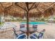 Relaxing poolside seating under a tiki umbrella at 400 Island Way # 1204, Clearwater, FL 33767