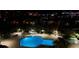 Night view of a community pool and spa, surrounded by lush landscaping at 400 Island Way # 1204, Clearwater, FL 33767