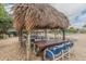 Poolside patio furniture under a thatched-roof palapa at 400 Island Way # 1204, Clearwater, FL 33767