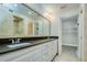 Elegant bathroom with double vanity, dark countertop and walk-in closet at 492 Santa Cruz Ne Pl # D, St Petersburg, FL 33703