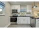 Modern kitchen with white cabinets and herringbone backsplash at 492 Santa Cruz Ne Pl # D, St Petersburg, FL 33703