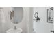 Small powder room with pedestal sink and oval mirror at 5249 Salt Marsh Rd, Wimauma, FL 33598