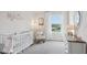 Bright Bedroom features a crib, rocking chair, and large window at 5249 Salt Marsh Rd, Wimauma, FL 33598