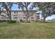 Condo building exterior with tree-lined lawn at 5725 80Th N St # 116, St Petersburg, FL 33709