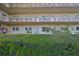 Condo building exterior with lush green hedge at 5725 80Th N St # 116, St Petersburg, FL 33709
