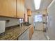 Galley-style kitchen with granite countertops and appliances at 5725 80Th N St # 116, St Petersburg, FL 33709