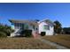White single story home with teal accents and a landscaped yard at 801 Woodruff Ave, Clearwater, FL 33756