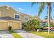 Tan two-story townhome with two-car garage and palm trees at 11246 Kapok Grand Cir, St Petersburg, FL 33708