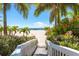 White boardwalk leads to a sandy beach with palm trees at 11398 88Th Ave, Seminole, FL 33772