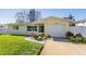 Updated yellow house with a white garage door and landscaped lawn at 11398 88Th Ave, Seminole, FL 33772