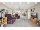 Spacious living room with armchairs and a view into the kitchen, offering an open floor plan at 1212 Wild Feather Ln, Sun City Center, FL 33573