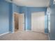 Light blue bedroom with carpeting and door to hallway at 1241 Redondo Way, Wesley Chapel, FL 33543
