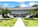Condo building with two-story exterior, white railings, palm trees, and walkway at 1250 S Pinellas Ave # 713, Tarpon Springs, FL 34689