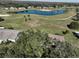Aerial view of home and community, showcasing golf course, lake, and lush landscaping at 1318 Leland Dr, Sun City Center, FL 33573