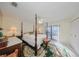 Bedroom with a four-poster bed, ceiling fan, and access to the patio at 1318 Leland Dr, Sun City Center, FL 33573