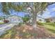 Front view of a white house with mature landscaping and a spacious driveway at 1318 Leland Dr, Sun City Center, FL 33573