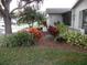 Landscaped yard with colorful plants and a spacious lawn area at 1318 Leland Dr, Sun City Center, FL 33573