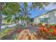 Landscaped front yard with tropical plants and a sitting area under a tree at 1318 Leland Dr, Sun City Center, FL 33573