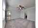 Large carpeted bedroom with ceiling fan and access to bathroom at 1610 Bonita Bluff Ct, Ruskin, FL 33570