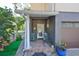 Cozy front porch with tile flooring, two green metal chairs, and colorful potted plants at 1745 E Mulberry Dr, Tampa, FL 33604