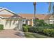 Villa features a two-car garage, manicured hedges, and a palm tree at 2315 New Orchard Ct, Sun City Center, FL 33573
