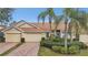 Beige exterior villa with double garage and lush landscaping at 2315 New Orchard Ct, Sun City Center, FL 33573