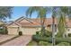 Attractive villa with two-car garage, lush landscaping, and brick paver driveway at 2315 New Orchard Ct, Sun City Center, FL 33573
