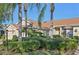 Front view of a charming villa with lush landscaping and a two-car garage at 2315 New Orchard Ct, Sun City Center, FL 33573