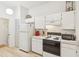 Well-equipped kitchen boasts white cabinets, a gas range, and light wood flooring at 2315 New Orchard Ct, Sun City Center, FL 33573