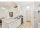 Galley kitchen with white cabinets, light wood flooring and stainless steel appliances at 2315 New Orchard Ct, Sun City Center, FL 33573