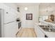 Bright eat-in kitchen features white cabinetry, modern appliances, and light wood flooring at 2315 New Orchard Ct, Sun City Center, FL 33573