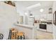 White kitchen with breakfast bar, light wood flooring and stainless steel appliances at 2315 New Orchard Ct, Sun City Center, FL 33573