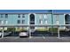 Building exterior featuring teal painted walls, covered parking, and landscaping at 255 114Th N Ave # 4, St Petersburg, FL 33716
