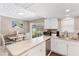 Modern kitchen with white cabinets, stainless steel appliances, and breakfast bar at 3064 Pinetree St, Port Charlotte, FL 33952
