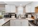 Modern kitchen with white cabinets, stainless steel appliances, and breakfast bar at 3064 Pinetree St, Port Charlotte, FL 33952